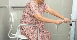 Woman sitting on a transfer bench in the bathroom