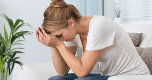 woman sitting at home feeling caregiver burnout